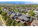 An elevated view reveals the neighborhood, showcasing the charming red two-story home with a gray roof and private deck at 13324 W 86Th Dr, Arvada, CO 80005
