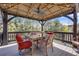 Outdoor deck featuring dining table under gazebo and forest views at 13324 W 86Th Dr, Arvada, CO 80005