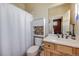 This bathroom features a toilet, vanity, sink, and shower with a neutral color palette at 13324 W 86Th Dr, Arvada, CO 80005