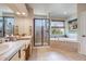 This bathroom boasts a double sink vanity, glass shower, soaking tub, and natural lighting at 13324 W 86Th Dr, Arvada, CO 80005