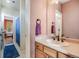Bathroom boasts a vanity with a sink, a large mirror, and a view to a bedroom and shower stall at 13324 W 86Th Dr, Arvada, CO 80005