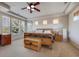 A primary bedroom offers windows with blinds, warm neutral colors, a ceiling fan, and furniture at 13324 W 86Th Dr, Arvada, CO 80005