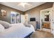 This comfortable carpeted bedroom boasts outside views, natural lighting, a dresser, and private bathroom at 13324 W 86Th Dr, Arvada, CO 80005
