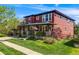 Attractive two-story home with a covered front porch, manicured lawn, and sidewalk at 13324 W 86Th Dr, Arvada, CO 80005