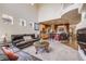 Spacious living room with an open floor plan, fireplace, and adjacent kitchen, perfect for relaxation and entertaining at 13324 W 86Th Dr, Arvada, CO 80005