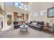 Bright living room with a fireplace, tall windows, and comfortable seating creates an inviting space at 13324 W 86Th Dr, Arvada, CO 80005