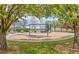 A charming playground on a gravel bed with play equipment and benches surrounded by blooming trees at 13324 W 86Th Dr, Arvada, CO 80005