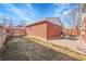 Backyard featuring a small lawn, stone patio with an outdoor dining set and brick garage at 4501 Bryant St, Denver, CO 80211