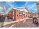 A stone patio features an outdoor dining set and BBQ, surrounded by a brick house and wooden fence at 4501 Bryant St, Denver, CO 80211