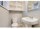 A cozy powder room features a pedestal sink, tiled floors, and built-in storage at 8408 W 62Nd Pl, Arvada, CO 80004