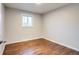 Cozy bedroom with hardwood flooring, neutral walls, and a bright window at 8408 W 62Nd Pl, Arvada, CO 80004