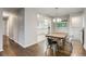 Open dining area with wood table, stylish chandelier, and view to modern kitchen at 8408 W 62Nd Pl, Arvada, CO 80004