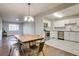 Bright dining area featuring modern chandelier, wood floors, and access to the updated kitchen at 8408 W 62Nd Pl, Arvada, CO 80004