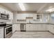 Contemporary kitchen boasts stainless steel appliances, white cabinets, and sleek countertop space at 8408 W 62Nd Pl, Arvada, CO 80004