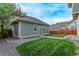 Home backyard view showing a grassy area and a building on the side at 2345 Akron St, Denver, CO 80238