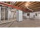 Unfinished basement space with exposed ceiling, concrete floor, and vintage fridge at 2345 Akron St, Denver, CO 80238