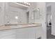 Bathroom featuring dual sinks, white cabinets, and a large mirror at 2345 Akron St, Denver, CO 80238