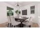 Bright dining room with modern chandelier, a spacious dark wood table, and six upholstered chairs at 2345 Akron St, Denver, CO 80238