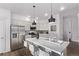 Well-lit kitchen with stainless steel refrigerator, modern lighting, and island seating at 2345 Akron St, Denver, CO 80238