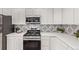 Updated kitchen with white cabinets, stainless steel appliances, and tile backsplash at 2345 Akron St, Denver, CO 80238