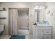 Bathroom featuring a tub with shower, a vanity sink with white cabinets, and neutral decor at 1775 Longbranch St, Strasburg, CO 80136
