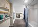 Cozy bathroom with gray tile floors, shower and tub combo, and white tiled walls and shelves at 1775 Longbranch St, Strasburg, CO 80136