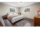 Well lit bedroom with a full sized bed, hardwood floors, and large windows providing outdoor views at 1775 Longbranch St, Strasburg, CO 80136