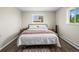 Bright bedroom featuring a full-size bed, hardwood floors, and windows for natural light at 1775 Longbranch St, Strasburg, CO 80136