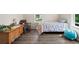 Comfortable bedroom with two windows offering natural light and hardwood floors at 1775 Longbranch St, Strasburg, CO 80136