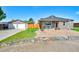 Charming house with a detached garage featuring a quilt-themed garage door and a well-kept lawn at 1775 Longbranch St, Strasburg, CO 80136