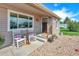 A cozy front porch featuring classic rocking chairs, colorful flower pots, and easy access to the front door at 1775 Longbranch St, Strasburg, CO 80136