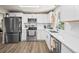 Bright modern kitchen with stainless appliances, white cabinets, and hardwood floors at 1775 Longbranch St, Strasburg, CO 80136