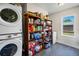 Organized laundry room with full sized washer and dryer, and extra storage shelving space at 1775 Longbranch St, Strasburg, CO 80136