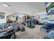 Large living room with carpeted floors, a couch, multiple windows, and plenty of decor at 1775 Longbranch St, Strasburg, CO 80136