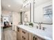 Bright bathroom with dual sinks, wood cabinetry, and a tiled shower-tub combo at 2310 Willow Creek Dr, Golden, CO 80401