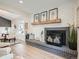 Bright living room with a painted brick fireplace, wood mantel, and light wood floors at 2310 Willow Creek Dr, Golden, CO 80401