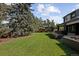 Lush backyard with a large grassy area, mature trees, and a clear view of the in-ground pool at 1 Sedgwick Dr, Cherry Hills Village, CO 80113