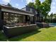 Spacious backyard patio with a dining area and outdoor lounge seating, complemented by manicured flower beds at 1 Sedgwick Dr, Cherry Hills Village, CO 80113