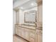 Bathroom featuring custom cabinets, granite counters, and a decorative mirror at 1 Sedgwick Dr, Cherry Hills Village, CO 80113