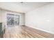 Bright living room with sliding door to balcony and hardwood floors at 14351 E Tennessee Ave # 305, Aurora, CO 80012
