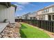 Spacious backyard featuring an artificial lawn and stone landscaping along the side of the home at 11103 Cloud Shadow St, Littleton, CO 80125