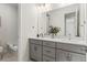 Bathroom with dual sinks, a large mirror, and tub with white subway tile at 11103 Cloud Shadow St, Littleton, CO 80125