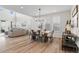 Bright open-concept dining area features wood floors, modern lighting, and a stylish table with seating for six at 11103 Cloud Shadow St, Littleton, CO 80125