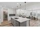 Bright and airy kitchen with a gray kitchen island, white cabinets and open layout to living room at 11103 Cloud Shadow St, Littleton, CO 80125