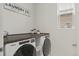 Functional laundry room with modern washer and dryer beneath a spacious countertop and decor at 11103 Cloud Shadow St, Littleton, CO 80125