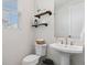 Elegant powder room featuring floating wood shelves and a pedestal sink with modern fixtures at 11103 Cloud Shadow St, Littleton, CO 80125