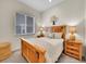 Cozy bedroom features a wood bed frame, side tables, and a window with blinds at 8894 River Peak Cir, Littleton, CO 80125