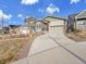 Street view showcasing a home with a large driveway, manicured lawn, and architectural design at 8894 River Peak Cir, Littleton, CO 80125