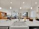 Elegant kitchen with large island featuring a farmhouse sink and a view of the open-concept living area at 8894 River Peak Cir, Littleton, CO 80125