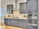 Modern kitchen features stainless steel appliances, gray cabinetry, and a light backsplash at 8894 River Peak Cir, Littleton, CO 80125